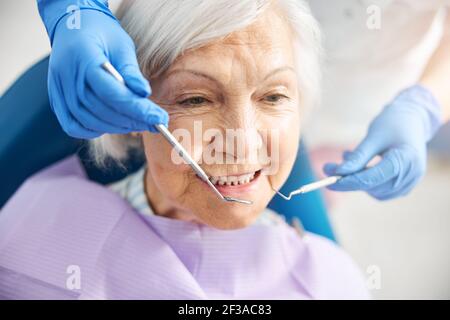 Donna anziana che riceve un trattamento dentale da un medico Foto Stock