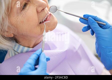 Ispezione dei denti eseguita con specchio dentale e sonda Foto Stock