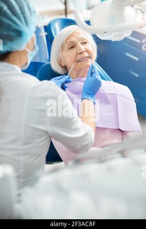 Donna anziana sotto esame dei denti dal dentista Foto Stock