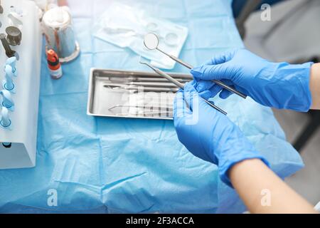 Specchio dentale e sonda nelle mani di una persona medica Foto Stock