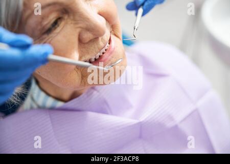 Valutazione dei denti della persona anziano con dispositivi dentali Foto Stock