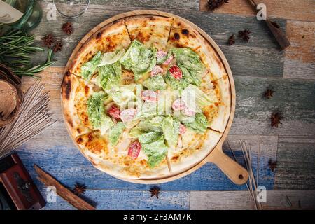 Pizza Caesar con insalata di iceberg e pomodori Foto Stock