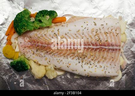 Piatto di pesce - pesce con verdure prima di cuocere in foglio Foto Stock