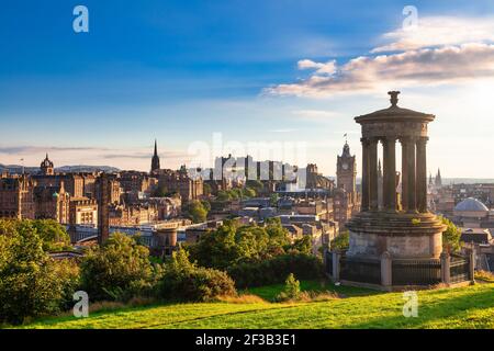 Il paesaggio urbano di Edimburgo, visto dalla collina di Calton con il Monumento a Dugald Stewart in primo piano al sole della sera Foto Stock