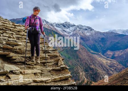 Trekking sul circuito di Dolpo trekking nella regione tipicamente tibetana occidentale del Nepal di Dolpo. Donna escursionista su percorso antico Foto Stock