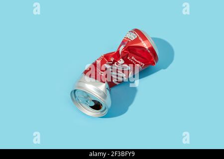 BANGKOK, THAILANDIA - 16 MARZO 2021: Rumpled Coca Cola CAN su sfondo blu Foto Stock
