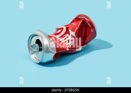 BANGKOK, THAILANDIA - 16 MARZO 2021: Rumpled Coca Cola CAN su sfondo blu Foto Stock