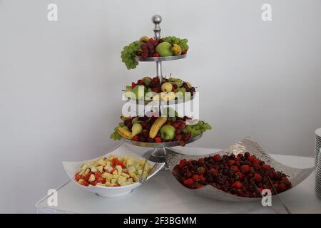 Una porzione di frutta fresca deliziosa in ciotole e piatti Foto Stock