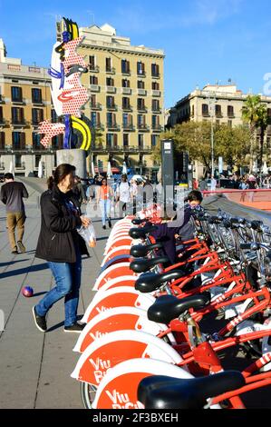 BARCELLONA, SPAGNA - 10 MARZO 2018: Donna e figli che scelgono le biciclette dal sistema di bici cittadino di Barcellona e la scultura surrealista El Cap de Barcelon Foto Stock