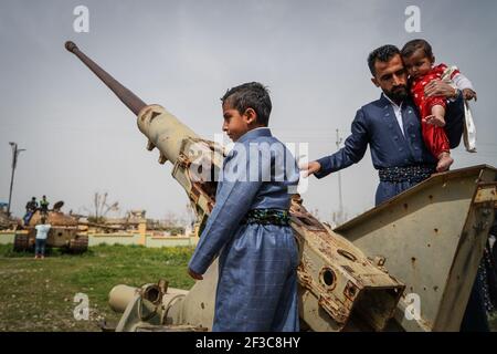 Halabja, Iraq. 16 Marzo 2021. Le persone che visitano il Monumento di Halabja ispezionano un veicolo militare che è stato usato nell'attacco chimico effettuato dal governo iracheno il 16 marzo 1988 durante i giorni di chiusura della·guerra iraniana in Iraq nella città curda di Halabja, che ha ucciso quasi 5000 persone e ha ferito circa 10000 persone, la maggior parte erano civili. Credit: Ismael Adnan/dpa/Alamy Live News Foto Stock