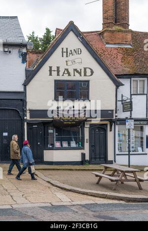 L'uomo e la donna maturi camminano oltre il pub mano in mano in High Street, Pinner, Middlesex, Inghilterra, Regno Unito Foto Stock