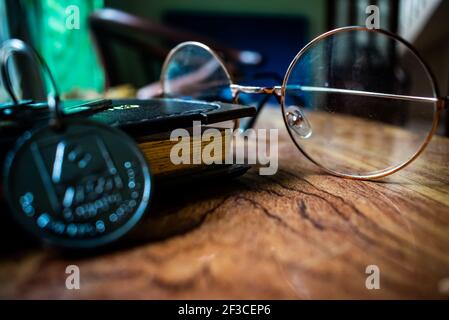 Bei vetri, taccuino e chiavi sul tavolo di legno marrone. Foto Stock