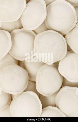 Pelmeni. Gnocchi surgelati con carne. Gnocchi vista dall'alto. Gnocchi grezzi con carne. Modello Varenyky. Foto Stock