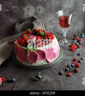 Torta con panna montata, frutti di bosco freschi e un bicchiere di bevanda. Copia spazio per testo. Foto Stock