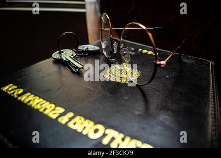 Bei vetri, taccuino e chiavi sul tavolo di legno marrone. Foto Stock