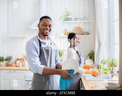 Happy black coppia piatti di lavaggio insieme in cucina, copia spazio. Concetto di doveri familiari Foto Stock