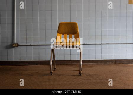 Una sedia gialla all'interno di una stanza blu. Foto Stock