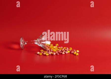 su sfondo rosso si trova un bicchiere di vino dolci Foto Stock