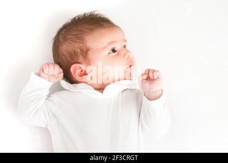 Una vista dall'alto di un neonato su un sfondo bianco con la mano chiusa Foto Stock