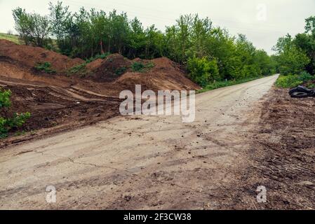 Percorsi di fango su una strada da cui erano stati lasciati veicoli da costruzione su strada e possono causare gravi pericoli per i driver Foto Stock