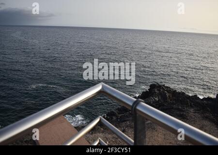 Oceano con rocce e vista sull'isola Foto Stock