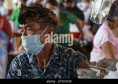 16 marzo 2021, Gianyar, Bali, Indonesia: Un operatore sanitario si è accaposto un vaccino Covid-19 verso un cittadino. Una vaccinazione di massa del Covid-19 verso i cittadini tenuta nel Grande Palazzo di Ubud, come fase del programma della zona Verde a Bali. Il programma della zona verde coinvolge tre regioni a Bali; Ubud, Sanur e Nusa Dua, sono pronti a preparare un piano di riapertura internazionale del turismo, che rientra nel focolaio. (Immagine di credito: © Dicky Bisinglasi/ZUMA Wire) Foto Stock