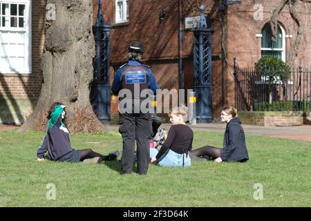 Un addetto al sostegno della Comunità di polizia ( PCSO ) i colloqui con un gruppo di adolescenti si sono riuniti su un Giornata di sole durante il blocco di Coronavirus in Hereford UK Foto Stock