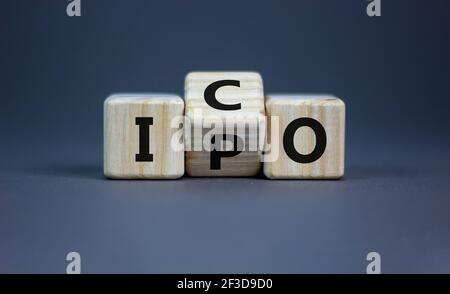 IPO vs ICO. Girò un cubo e cambiò la parola 'IPO - offerta pubblica iniziale' in 'ICO - offerta moneta iniziale'. Bel tavolo grigio. Sfondo grigio Foto Stock