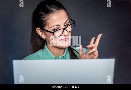 Giovane donna d'affari che ha videochiamata. Isolato su sfondo scuro Foto Stock