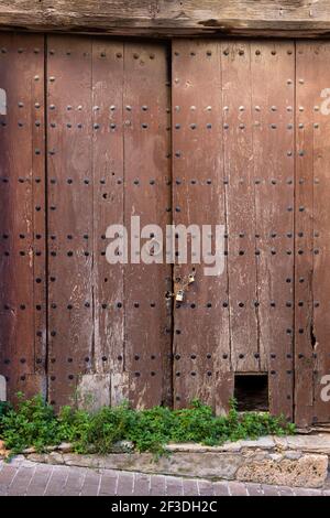 Vecchia porta in legno con arco in pietra, a Girona, Catalogna, Spagna Foto Stock