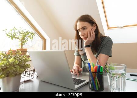 Donne che lavorano da casa in un mansarda in un giorno di sole. Nuovo normale. Foto Stock