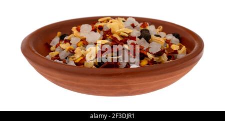 Vista laterale di una piccola ciotola in argilla con una porzione di aglio e peperoncino isolato su sfondo bianco. Foto Stock