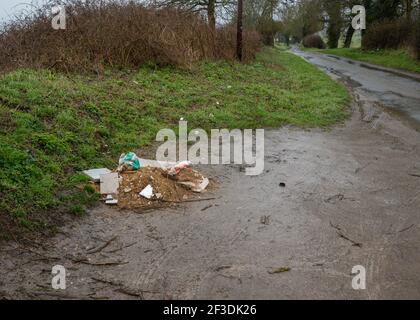 I rifiuti dei costruttori sono scappati sul lato di una strada di campagna del Norfolk. Foto Stock