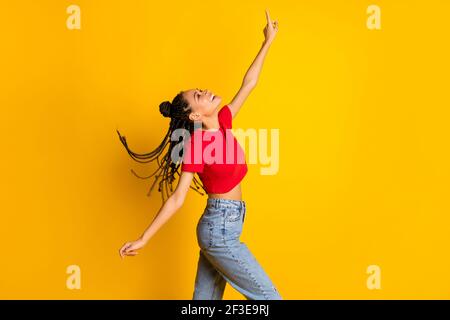 Profilo ritratto vista laterale di bella ragazza allegra godendo di ballare avere divertimento freddo isolato su sfondo giallo brillante Foto Stock