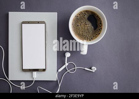 Telefono con schermo bianco vuoto e caffè Foto Stock