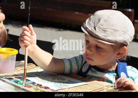 Il disegno figlio con pennello e acquerelli Foto Stock