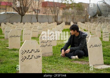 Un uomo siede nel cimitero delle vittime dell'attacco chimico di Halabja.il 33° anniversario dell'attacco chimico effettuato dal governo iracheno il 16 marzo 1988 sulla città di Halabja nella regione del Kurdistan, che ha ucciso quasi 5000 persone e ha ferito 10000 la maggior parte di loro civili. Migliaia di abitanti della città sono morti nell'anno successivo all'attacco a causa di complicazioni sanitarie e a causa di malattie e difetti congeniti. Foto Stock