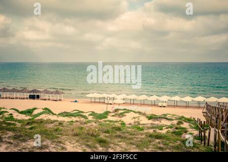 paesaggio di una spiaggia tranquilla e solitaria su una nuvolosa giorno Foto Stock