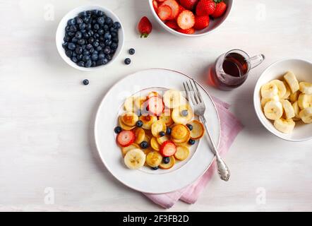 Cibo alla moda - cereali pancake. Prima colazione con minuscoli pancake e frutti di bosco. Vista dall'alto. Foto Stock