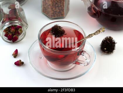 Tè alle erbe fatto in casa. Un rimedio che aumenta l'immunità e allevia lo stress. Teiera in vetro e tè con una bevanda calda e sana. Vasi trasparenti con lei asciugata Foto Stock