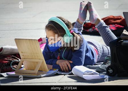 Studente italiano prende lezioni di apprendimento a distanza per strada in protesta della chiusura della scuola di Covid Torino, Italia - Marzo 2021 Foto Stock