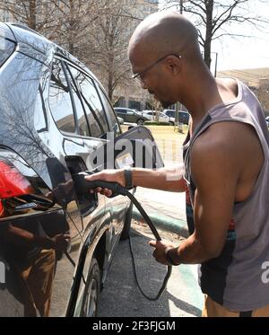 Montgomery, Alabama, Stati Uniti. 14 Marzo 2021. MICHAH JEFFERSON SAHA utilizza una stazione di ricarica municipale per ricaricare la sua Toyota, la sua auto ibrida con presa a 4 prime, nel centro di Montgomery, Alabama, domenica 14 2021 marzo. (Immagine di credito: © Mark HertzbergZUMA Wire) Foto Stock