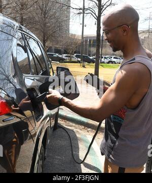 Montgomery, Alabama, Stati Uniti. 14 Marzo 2021. MICHAH JEFFERSON SAHA utilizza una stazione di ricarica municipale per ricaricare la sua Toyota, la sua auto ibrida con presa a 4 prime, nel centro di Montgomery, Alabama, domenica 14 2021 marzo. (Immagine di credito: © Mark HertzbergZUMA Wire) Foto Stock