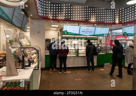 New York, NY - 16 marzo 2021: Il negozio più importante di Krispy Kreme su Times Square è uno dei luoghi in cui i fan possono ricevere gratuitamente Green Donuts per la celebrazione del giorno di San Patrizio Foto Stock