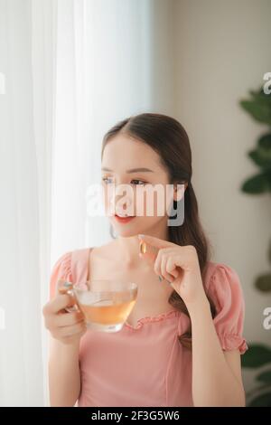 Belle Donne asiatiche dieta salutare mangiare vitamina pillola con acqua Foto Stock