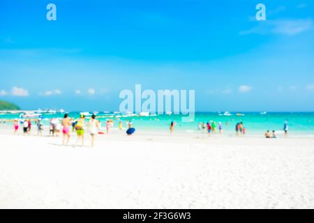 Sfumata la gente sulla spiaggia di sabbia bianca con mare blu un sfondo cielo Foto Stock