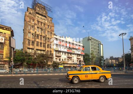 Taxi giallo sulla strada cittadina con vista sugli edifici degli uffici A Esplanade zona di Kolkata Foto Stock