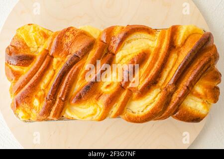 Torta di turbolenza al lievito al forno, brioche tradizionale francese, con personale di formaggio cremoso primo piano su tavola di servizio in legno, piatto Foto Stock