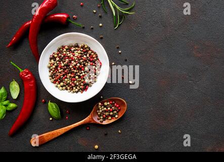 Grani e cialde di peperoncino rosso caldo su sfondo scuro, vista dall'alto Foto Stock