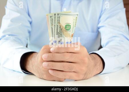 Mani che tengono soldi, dollari USA (USD) fatture, sul tavolo Foto Stock